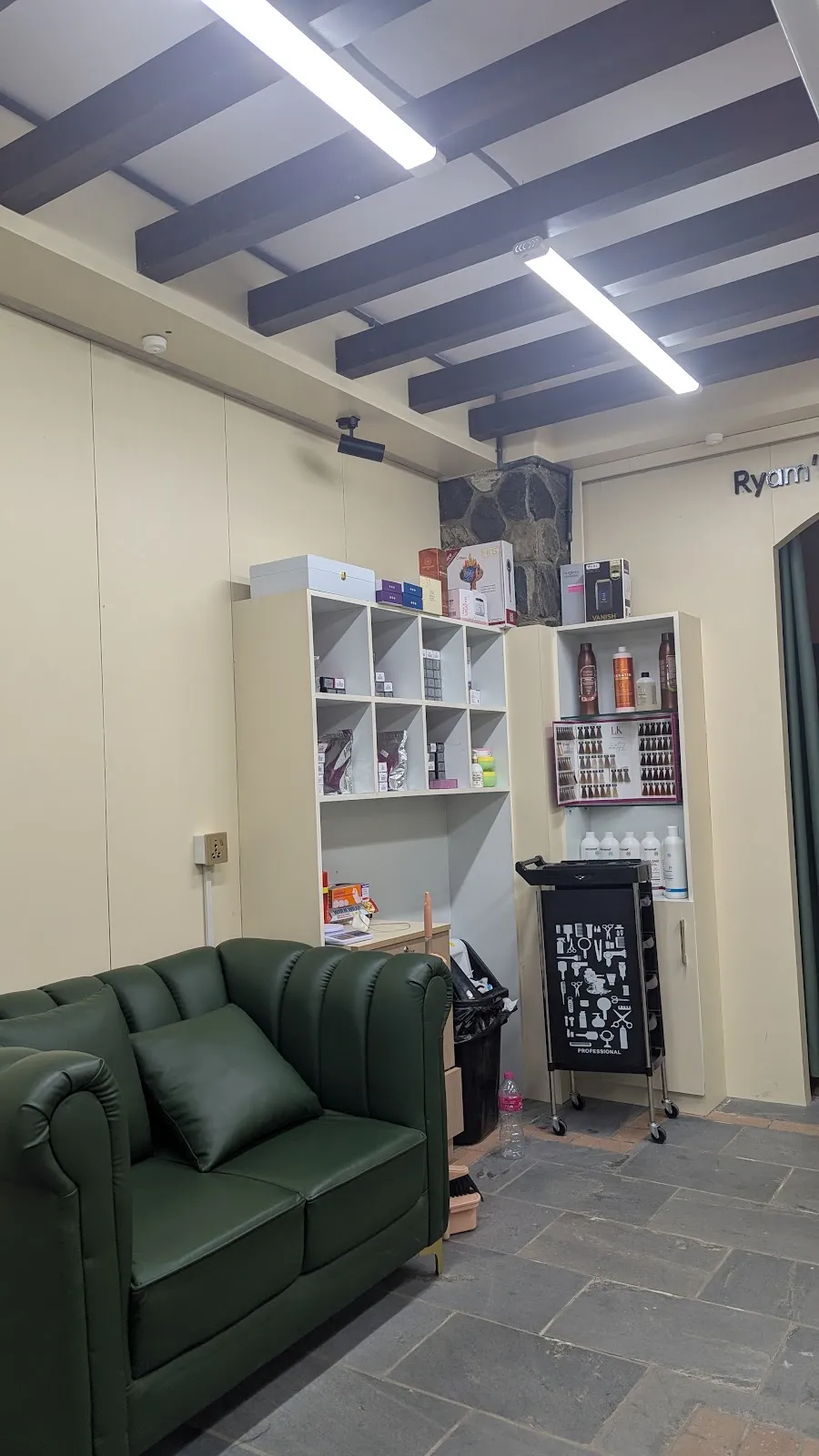 Green leather lounge sofa and product shelves in the waiting corner